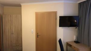 a room with a door with a television on the wall at Löns Hotel Garni in Garbsen +17 photos