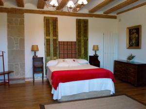 a bedroom with a large bed with a red blanket at La Casona de Pitillas in Pitillas