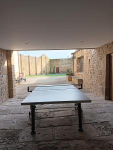 a ping pong table in a courtyard with a building at La Casona de Pitillas in Pitillas