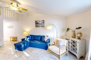 a living room with a blue couch and a chair at Sand Dollar E201 in Pensacola Beach +37 photos