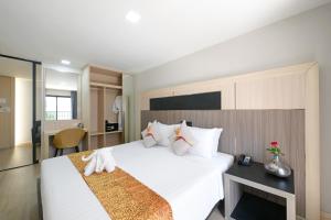 a hotel room with a large white bed and a desk at O2 Grand Suvarnabhumi Airport - Free Scheduled Shuttle from Hotel to Suvarnabhumi Airport in Bang Phli