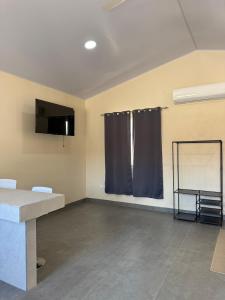 an empty room with a table and a window at Estancia tranquila y cómoda in Jacó