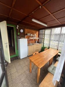 a kitchen with a wooden table and a refrigerator at Chata Pod Bílým kamenem in Doksy