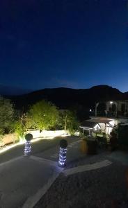 a patio with lights on the side of a house at night at George house in Leonidio