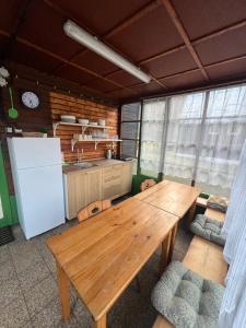 a kitchen with a wooden table and a refrigerator at Chata Pod Bílým kamenem in Doksy
