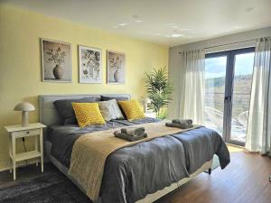 a bedroom with a bed and a large window at Luxus-Penthouse mit Panorama-View in Netphen