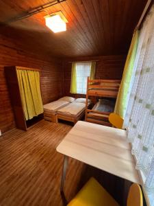 a room with two bunk beds and a table at Chata Pod Bílým kamenem in Doksy