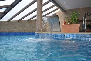 a swimming pool with a water fountain at Apartamentos Spa Casco Historico de Isla in Isla