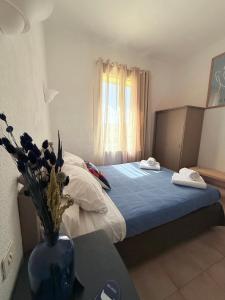 a bedroom with a bed and a vase with flowers on a table at La Châtaigneraie in Evisa