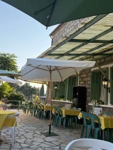 a row of tables and chairs with an umbrella at La Châtaigneraie in Evisa
