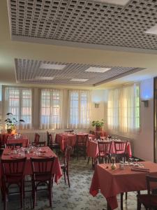 a dining room with red tables and chairs and windows at La Châtaigneraie in Evisa