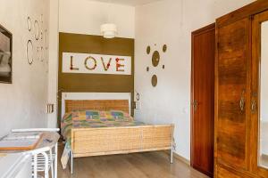a bedroom with a bed with a love sign on the wall at Stanza con terrazzo vista lago LAKEHOLIDAY IT in Castel di Tora