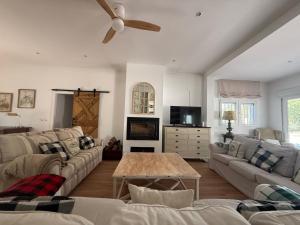 a living room with couches and a ceiling fan at Villa El Carmen in Sanlúcar la Mayor