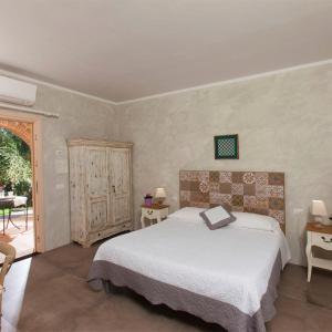 a bedroom with a white bed and a patio at Bio Agriturismo Le Cascatelle in Saturnia