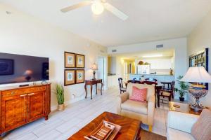 a living room with a couch and a dining room at Calypso 906W in Panama City Beach