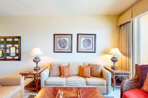 a living room with a couch and two tables at Calypso 906W in Panama City Beach