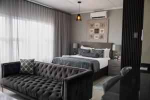 a bedroom with a bed and a couch in front of it at Umdloti Luxe Horizon in Umdloti +67 photos