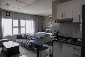 a kitchen and a living room with a couch at Umdloti Luxe Horizon in Umdloti