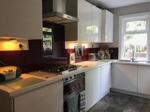 a kitchen with white cabinets and a stove top oven at Stunning 3 bed house by Endcliffe Park in Nether Edge