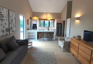 a living room with a couch and a kitchen at Chamallow Nature Lodge in Grande Case Noyale