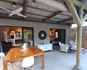a living room with a wooden table and chairs at Chamallow Nature Lodge in Grande Case Noyale