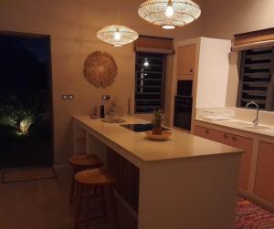a kitchen with a large island with two bar stools at Chamallow Nature Lodge in Grande Case Noyale +16 photos