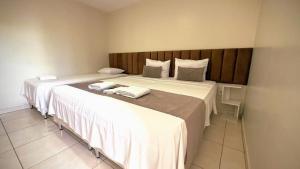 a bedroom with two beds with white sheets and towels at Rio Hotel in Petrolândia
