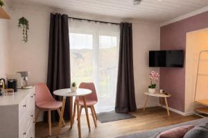 a living room with a table and chairs and a window at Ringdays Guesthouse in Müllenbach