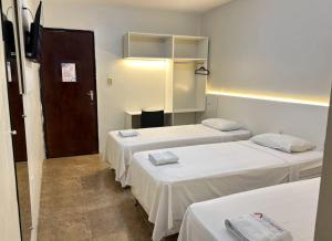 a room with three beds and a door in it at Rio Hotel in Petrolândia +6 photos