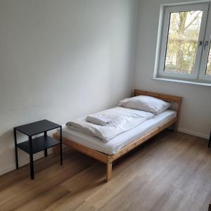 a bed in a room with a table and a window at Appartement mit 3 Zimmern in Straubing
