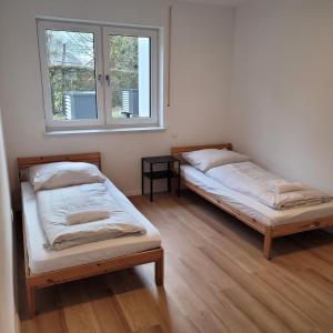 two beds in a room with two windows at Appartement mit 3 Zimmern in Straubing