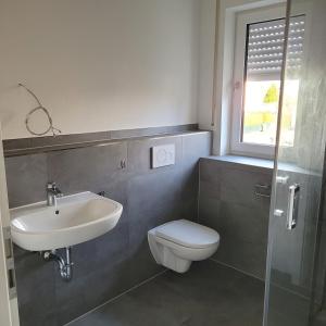 a bathroom with a sink and a toilet and a window at Appartement mit 3 Zimmern in Straubing