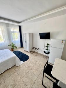 a bedroom with a bed and a flat screen tv at Eda Sultan Guesthouse - 5 Min Walk to Göynük Beach in Kemer