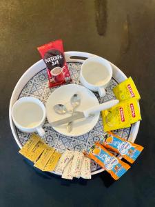 a table with a plate with a spoon and a cup and aucer at Murree Spring Apartment in Murree