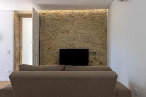 a living room with a couch and a tv at Casa de Algeriz in Algeriz