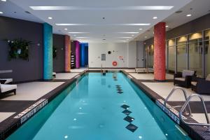 ein Swimmingpool in einer Hotellobby mit Stühlen und Tischen in der Unterkunft Grey Eagle Resort in Calgary