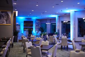 ein Esszimmer mit Tischen und Stühlen und blauer Beleuchtung in der Unterkunft Grey Eagle Resort in Calgary
