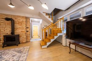 a living room with a television and a brick wall at Domek nad rzeką in Joniec