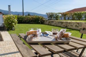 a tray of bread and drinks on a picnic table at Casa de Algeriz in Algeriz