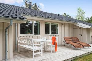 a patio with chairs and a table on a deck at VE303-Oksbol-Kaervej-2 in Oksbøl