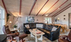 a living room with leather furniture and a table at VE264-Vejers-Strand-Jafdalvej-95 in Vejers Strand