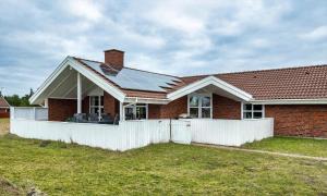 a red brick house with a white fence in front of it at VE264-Vejers-Strand-Jafdalvej-95 in Vejers Strand