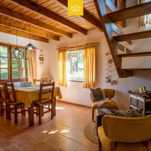 a kitchen and dining room with a table and chairs at LAS PRINCESAS Cabañas frente al rio in Los Reartes