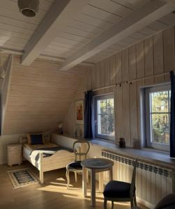 a bedroom with a bed and a table and chairs at Akacjowe Wzgórze in Wielęcin