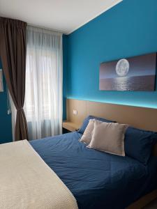 a blue bedroom with a bed with a blue wall at HOUSE on sunday LUNA in Crotone