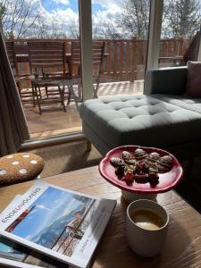 a table with a plate of donuts and a book at La Cachette De Durbuy - Chalet 203 in Durbuy +41 photos
