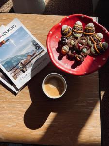 a plate of cookies on a table with a book and a cup of coffee at La Cachette De Durbuy - Chalet 203 in Durbuy