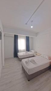 a room with two beds and a window in it at Mustafa Hotel Restaurant in Pamukkale
