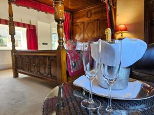 two wine glasses on a table in a bedroom at The Oxenham Arms Hotel Devon in South Zeal