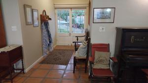 a room with chairs and a door and a piano at Restio in Agulhas